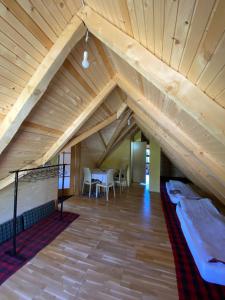 a room with a loft with a bed and a table at Prokoško jezero Zlatna koliba in Fojnica