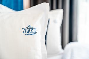 une rangée de chaises blanches avec un logo sur elles dans l'établissement Apartamenty w Zatoce, à Mikołajki