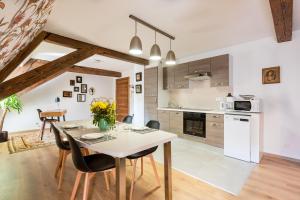 cocina y comedor con mesa y sillas en LE RHENANUS Hans Sapidus - appartement spacieux, au calme - parking gratuit, en Sélestat