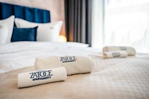 4 almohadas en una cama en una habitación de hotel en Apartamenty w Zatoce, en Mikołajki