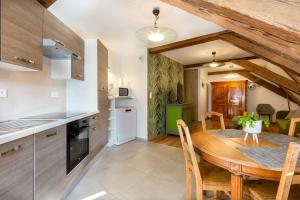 a kitchen and dining room with a wooden table at Jacques Spiegel Sélestat - Parking gratuit - Proche Europa-Park - Route des Vins - Haut-Koenigsbourg in Sélestat