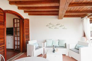 una sala de estar con muebles blancos y techo de madera. en [PORTO CERVO MARINA] Incantevole appartamento vista Yacht en Porto Cervo