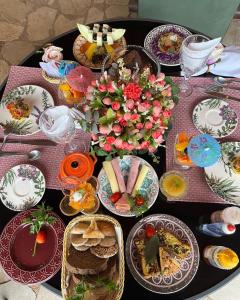 - une table avec des assiettes de nourriture et des fleurs dans l'établissement Pousada Vilagio Chapada, à Chapada dos Guimarães