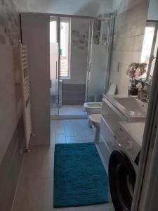uma casa de banho com um lavatório, um WC e um tapete em Casa del Porto em Savona