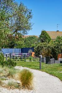 a garden with chairs and a table in a yard at La Cremaillere Hôtel-Restaurant in Courseulles-sur-Mer