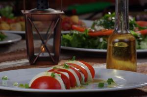a plate of food with tomatoes on a table at Guest House Dan Kolov in Syennik