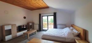 a bedroom with a bed and a television and a table at Apartmani Aleksandra in Kolašin