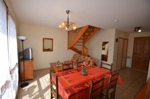 uma sala de jantar com uma mesa e uma escada em Apartments Gite le Picors em Aucun