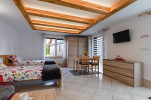 a living room with a bed and a dining room at Domek Rodzinny na Roztoczu in Nowiny
