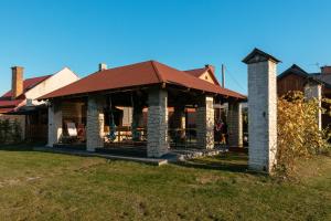 a house with a red roof on a yard at Domek Rodzinny na Roztoczu in Nowiny