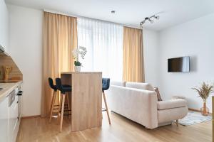 ein Wohnzimmer mit einem Sofa und einem Tisch in der Unterkunft Mila Apartment Vienna in Wien