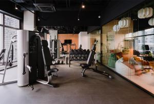 a gym with treadmills and exercise equipment on the wall at Apartament City Spa - Sokolska 30 Towers in Katowice