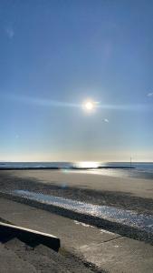 a beach with the sun rising over the water at Ifan cottage - two bedroom cottage in Meliden