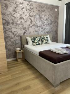 a bedroom with a large bed with a wooden floor at Happy Apartments Mamaia Nord -2 Dormitoare in Mamaia Sat/Năvodari