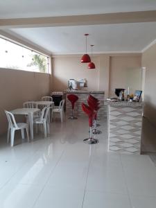 una cocina con sillas y mesas rojas en una habitación en Pousada Frei Galvão, en Cachoeira Paulista
