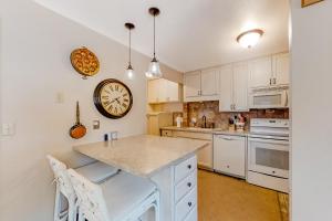 a kitchen with white cabinets and a clock on the wall at Alpine Gem in Park City