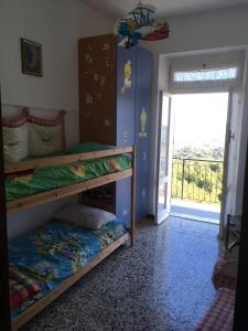 sypialnia z 2 łóżkami piętrowymi i przesuwnymi szklanymi drzwiami w obiekcie A cà du Baciccia w mieście Oneto