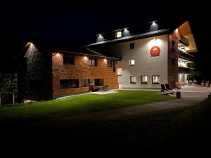 a building with a sign on the side of it at night at Alpin - Studios & Suites in Warth am Arlberg