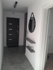 a hallway with a mirror and a black door at Apartament Wiżajny in Wiżajny