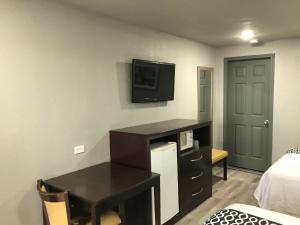 um quarto com uma secretária e uma televisão na parede em Budget Inn Valparaiso/Niceville @ Eglin AFB & Destin-FWB Airport em Niceville