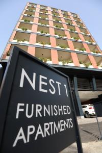 a sign in front of a tall building at Nest 1 Hotel in Beirut