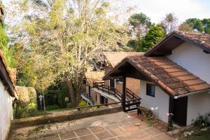 a house with a staircase next to a building at Pousada Estrela da Serra in Monte Verde
