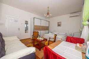 una sala de estar con dos camas y una mesa en Double Bedroom Seaview, en Crikvenica