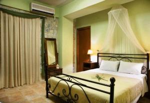 1 dormitorio con 1 cama grande con dosel en Vlyhada Guesthouse, en Pyrgos Dirou