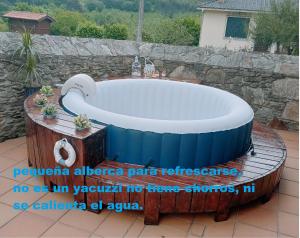 bañera grande en un patio con pared de piedra en Casa Rural Oza dos Ríos en Oza dos Ríos