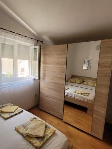 a bedroom with two beds and a window at Apartments Matanovic in Rogoznica