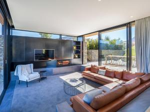 a living room with a couch and a fireplace at Point Vista - Queenstown Luxury in Queenstown