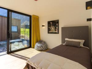 a bedroom with a bed and a large window at Point Vista - Queenstown Luxury in Queenstown