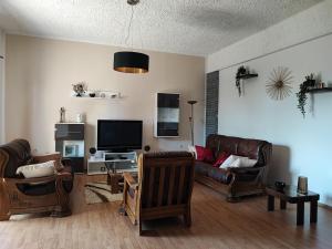 a living room with leather furniture and a flat screen tv at Priska Apartment in Kaštela
