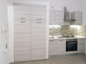 uma cozinha com armários brancos e um lavatório em Casa Al Massimo em Palermo