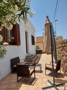 une terrasse avec une table, un parasol et des chaises dans l'établissement Birbiciù, à Pantelleria