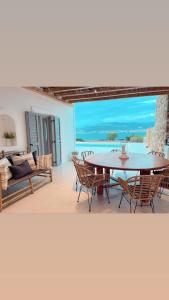 a patio with a table and chairs and a view of the ocean at Voras Villa Panagia Beach in Antiparos