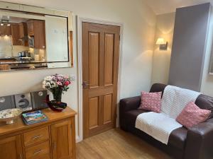 a living room with a couch and a table with flowers at Palmers Lodge in Launceston