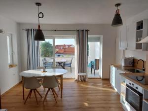 a kitchen and dining room with a table and chairs at Seaview Apartment Villa Sia in Vantačići