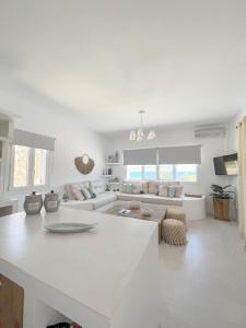 a white kitchen and living room with a large island at Voras Villa Panagia Beach in Antiparos