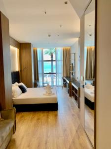 a bedroom with a bed and a desk and a mirror at ELMAR HOTEL in Vlorë