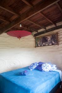 - une chambre dotée d'un lit bleu avec deux parasols sur le mur dans l'établissement Sítio Monte Alegre, à Ibicoara