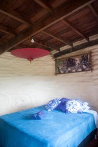 a bedroom with a blue bed with two umbrellas on the wall at Sítio Monte Alegre in Ibicoara
