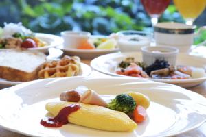 une table avec des assiettes de nourriture sur une table dans l'établissement Rihga Royal Hotel Hiroshima, à Hiroshima