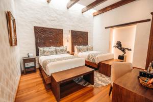 a hotel room with two beds and a table at Mama Cuchara by Art Hotels in Quito