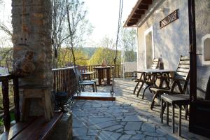 eine Terrasse mit Stühlen und Tischen auf einem Gebäude in der Unterkunft Noula's and Giorgos' Cottage in Desfina village- near Delphi in Dhesfína