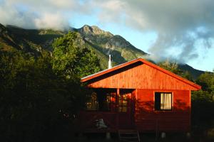 una cabina roja con una montaña en el fondo en Don Guillermo Cabins, en Las Trancas