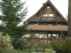 a house with a balcony with flowers on it at Pension Bergseeblick in Titisee-Neustadt +18 photos