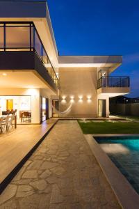 a modern house with a swimming pool at night at LUXURIOUS NEW HOUSE, UNFORGETABLE EXPERIENCE. in Canoa Quebrada