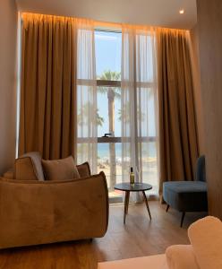a living room with a couch and a large window at ELMAR HOTEL in Vlorë