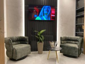 a room with two chairs and a tv on a wall at ELMAR HOTEL in Vlorë